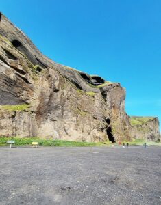 Czarna plaża i w dali wejście do jaskini